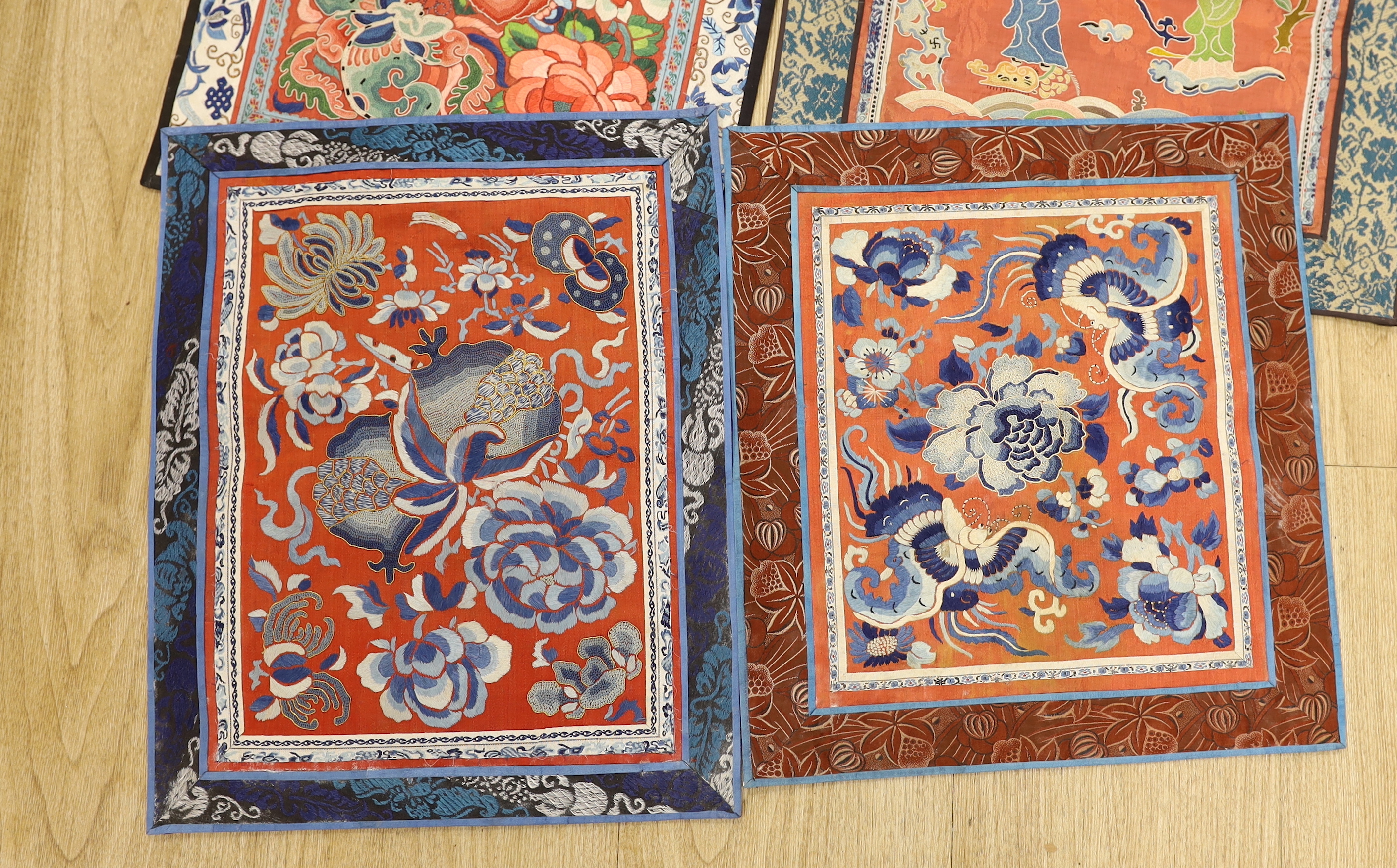 Six Chinese silk embroidered panels, embroidered with Beijing knot and stem stitch, using auspicious symbols: figures, flowers, butterflies and one with a dragon, five bordered with silk brocade, largest 48cm high x 32cm